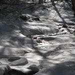 Stream surrounded by snow and ice