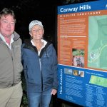 A man and woman stand to the left of the Conway Hills Wildlife Sanctuary Kiosk