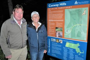 A man and woman stand to the left of the Conway Hills Wildlife Sanctuary Kiosk