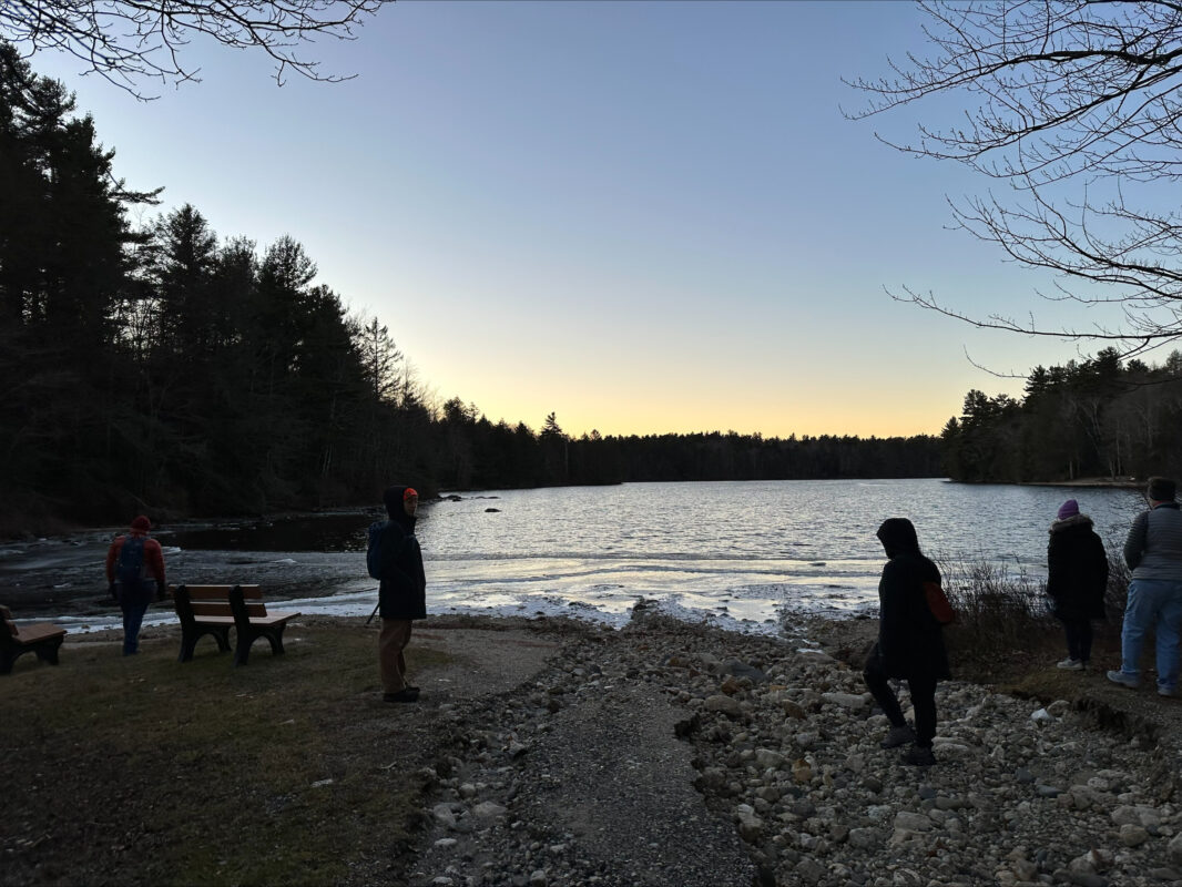 Hikers gathered on the boat launch beach to watch yellow and orange lights painted across the sky.