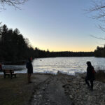 Hikers gathered on the boat launch beach to watch yellow and orange lights painted across the sky.